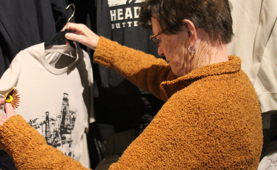 older woman looks at shirt while clothing shopping