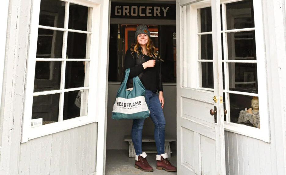 Woman stands with reusable bag